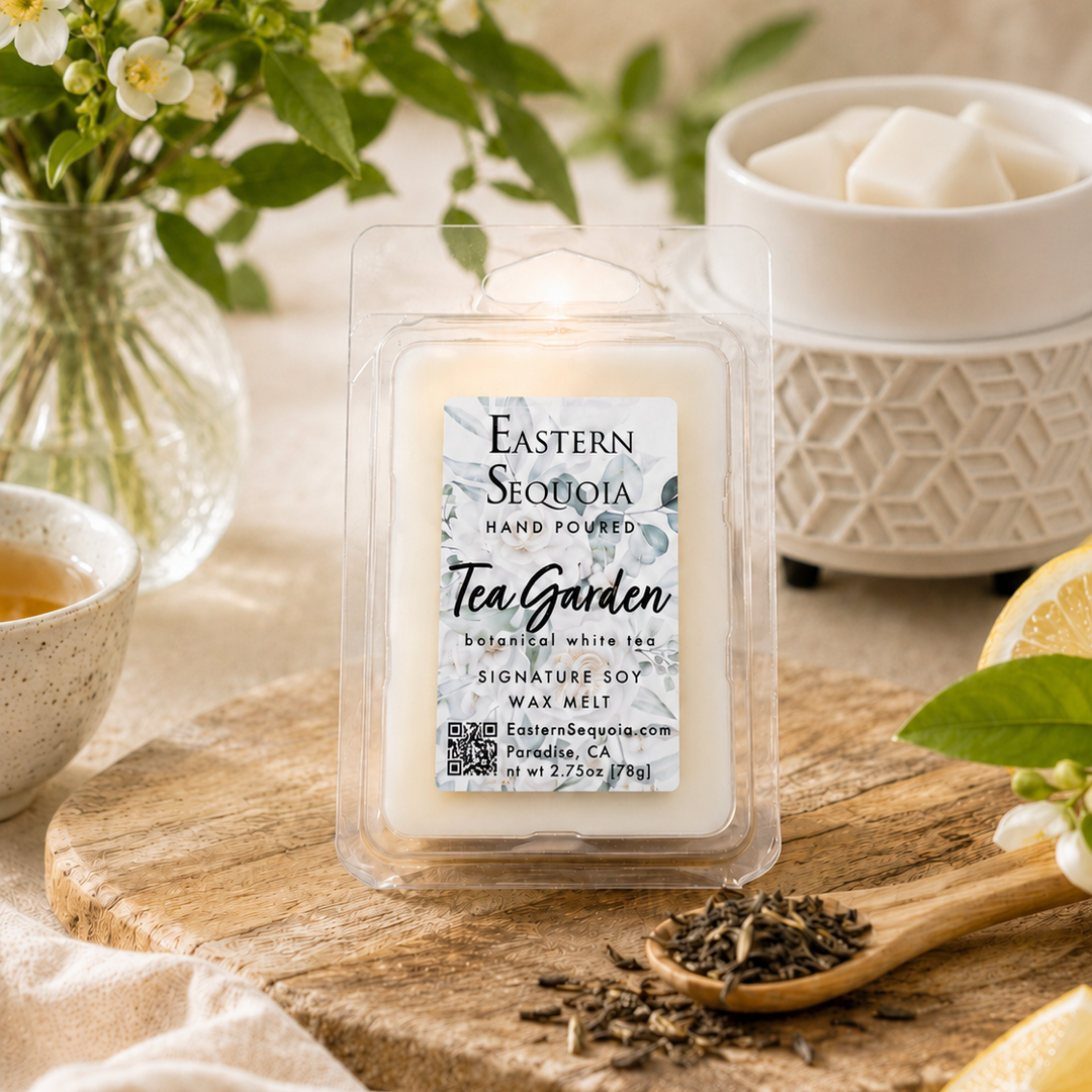 Packaged wax melt with 'Eastern Sequoia' branding on a wooden board with tea leaves and flowers.