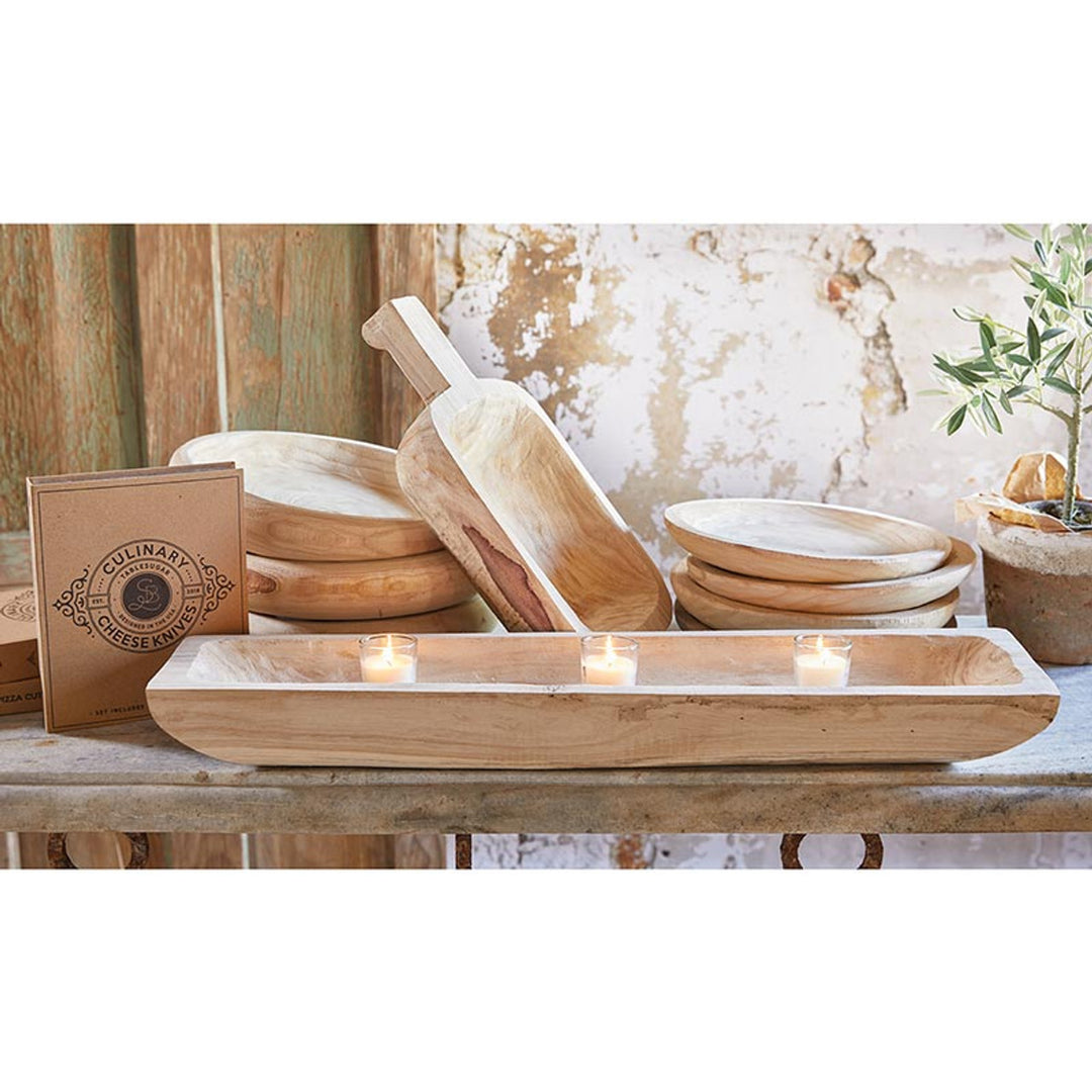 A rectangular natural wood tray with a 26-inch width, displayed in a rustic setting with candles and other wooden items in the background.
