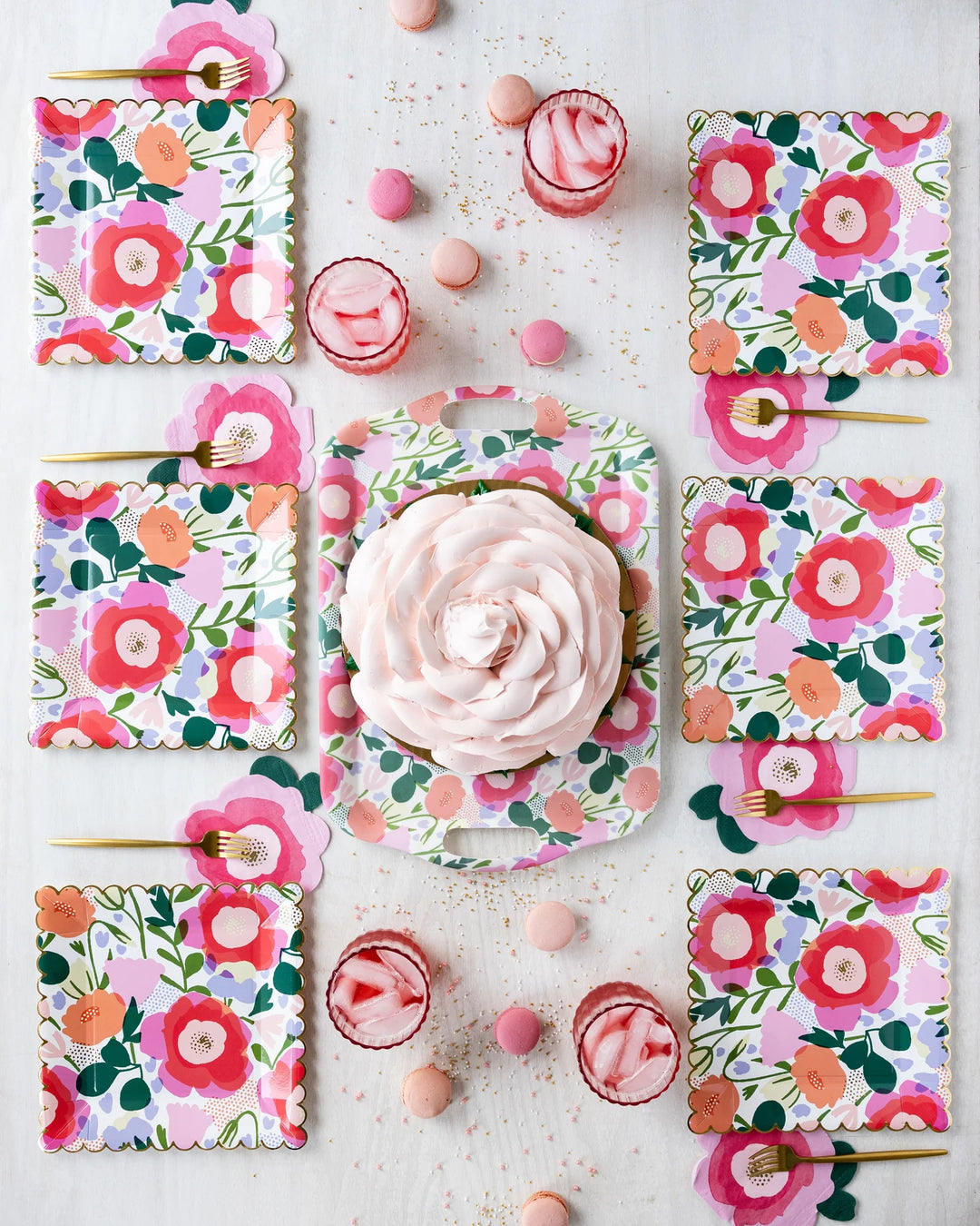 Decorative plates with floral patterns and a pink dessert on a light background