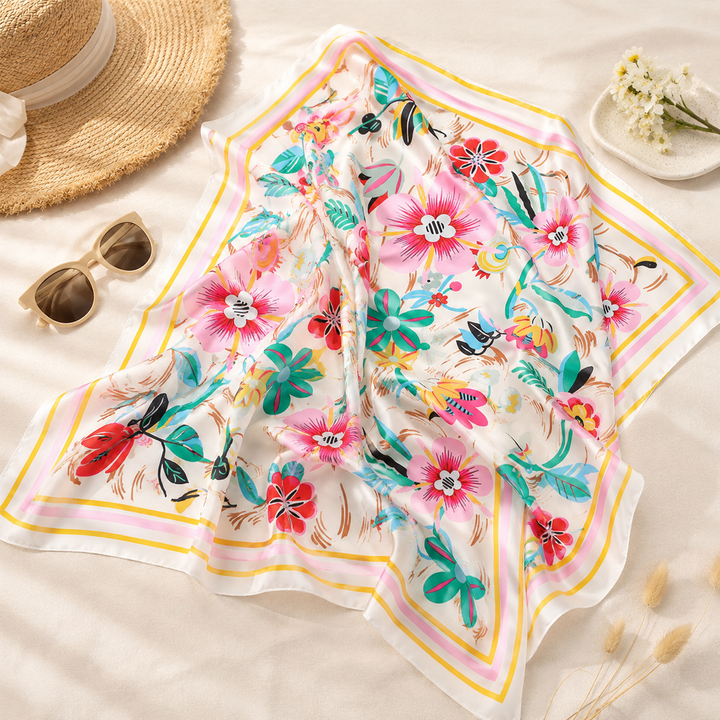 Floral scarf with sunglasses and a hat on a light background