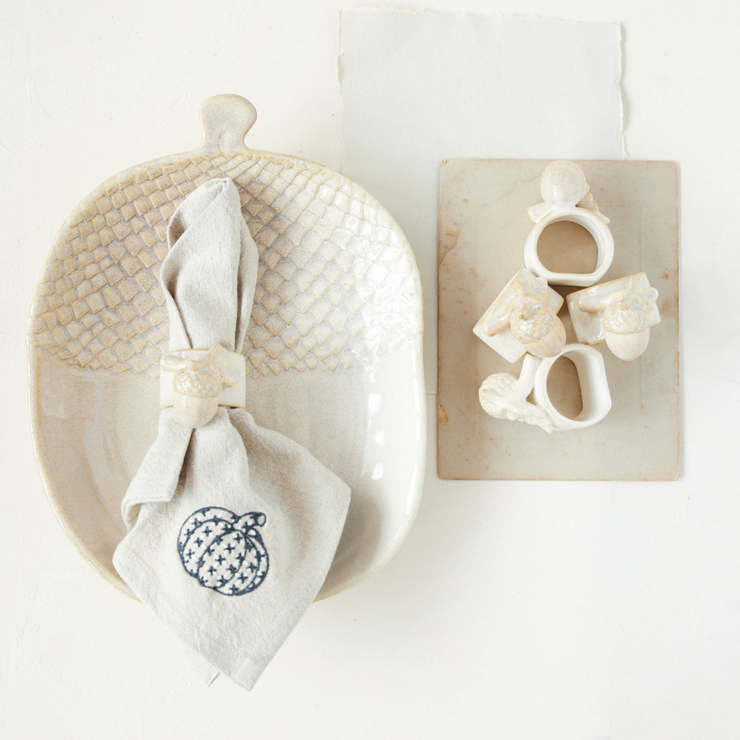 Decorative items including a woven basket, white napkin with a pumpkin design, and wooden blocks with letters on a white background.