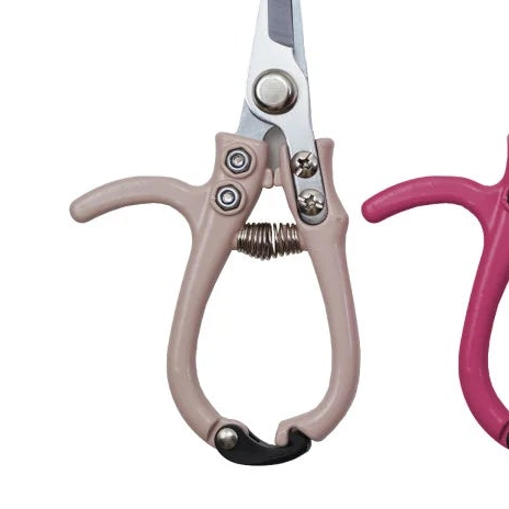 Pair of shears with beige and black handles on a white background