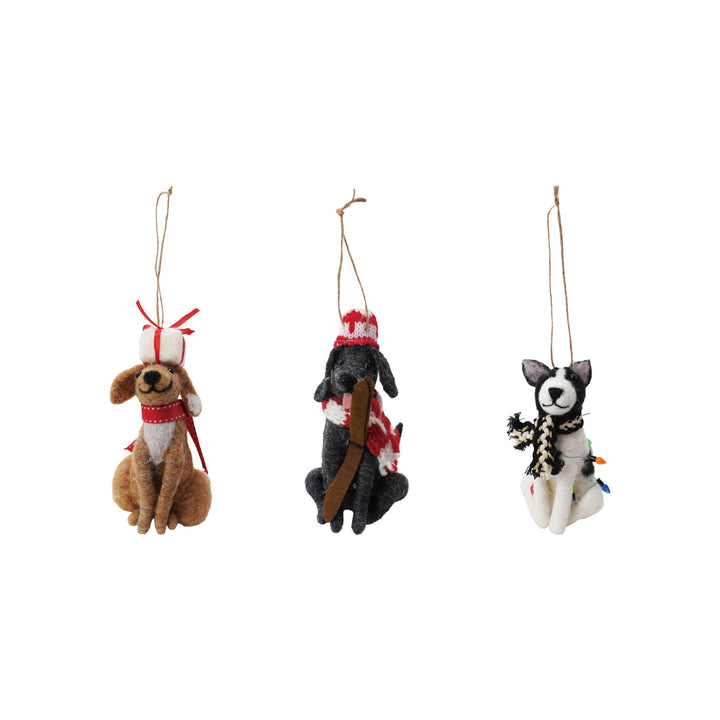 Three dog-shaped Christmas ornaments with scarves on a white background